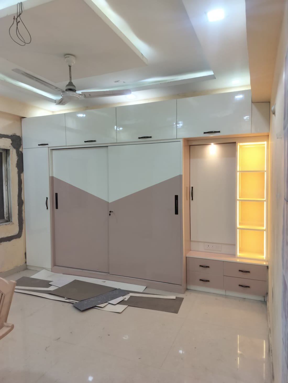 Mauve and white sliding wardrobe with backlit display shelf