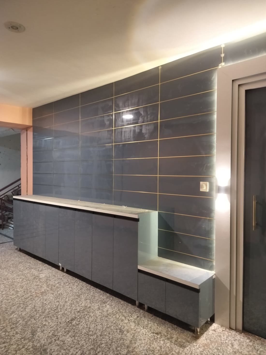 Long grey wall panel cabinet unit with backlit gold trim