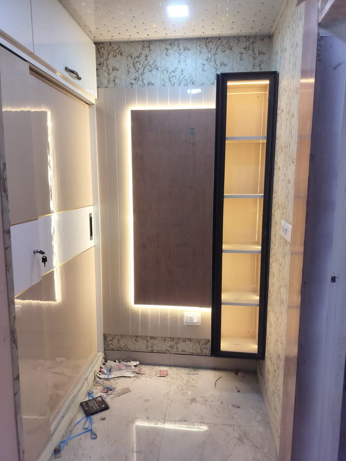 Wardrobe wall with backlit wood panel and glass display column